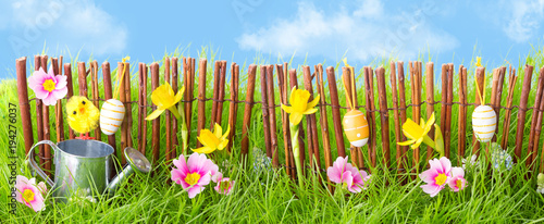 Oster Hintergrund  -- Gartenzaun mit Blumen und Gras, blauer Himmel
