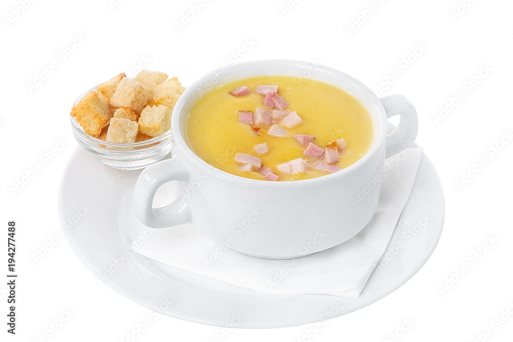 Soup puree, cream soup yellow with ham and croutons, dry bread. On a napkin in a white plate isolated white. Serving dishes in a cafe, restaurant, for a menu. Side view Soup puree, cream soup yellow with ham and croutons, dry bread. On a napkin in a white plate isolated white. Serving dishes in a cafe, restaurant, for a menu. Side view
