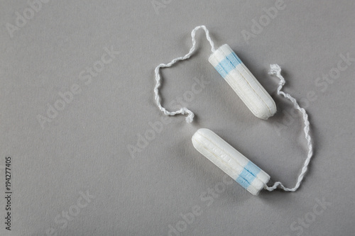 Means of protection of female hygiene. Hygienic tampons on a gray background. Organic gaskets made of bio-cotton. Menstrual cycle.