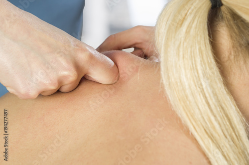Chiropractor  physiotherapist examining her patient back and doing decontracting massage. Osteopathy
