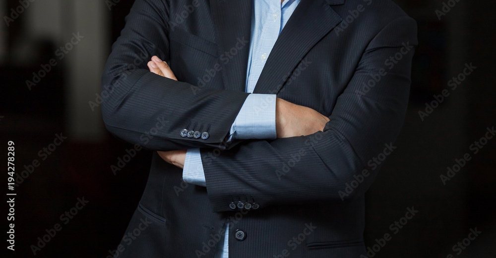 Close up cropped caucasian man hands and arms folded in a smart navy suit