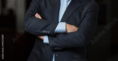 Obraz na plátně Close up cropped caucasian man hands and arms folded in a smart navy suit