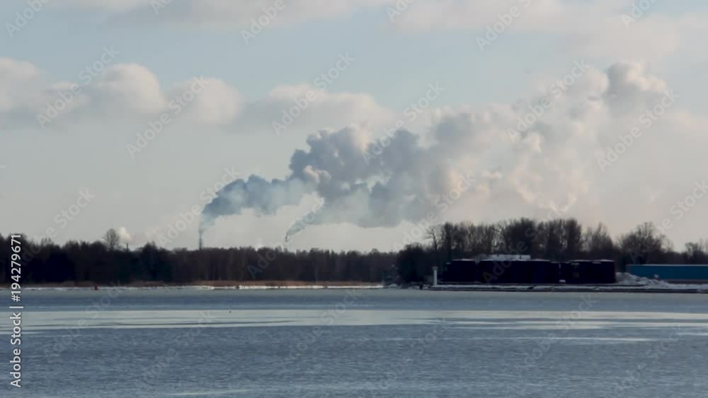 white chimney smoke in oil terminal Latvia sunny day winter river daugava in Latvia white chimney smoke in oil terminal Latvia sunny day winter river daugava in Latvia