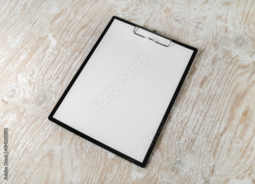 Clipboard with blank letterhead on wood table background. Stationery mockup with plenty of copy space.