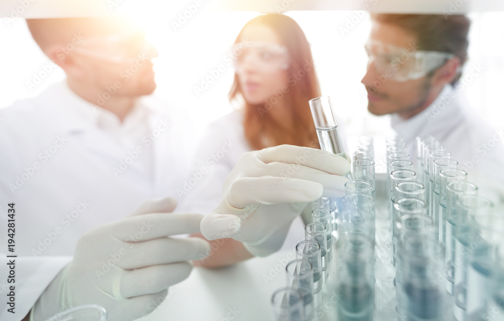 background image is a group of scientists studying the liquid in background image is a group of scientists studying the liquid in