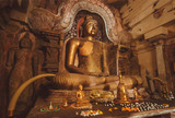 Interior of 14th century buddhist temple with stone figure of meditating Buddha in old decoration