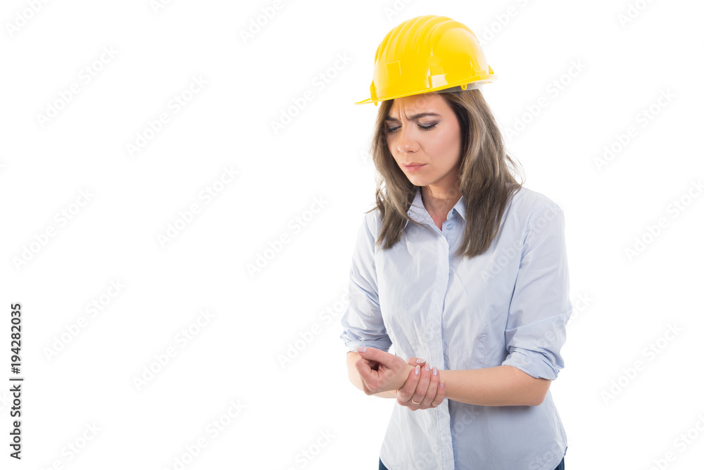 Portrait of female constructor holding her wrist. Portrait of female constructor holding her wrist.