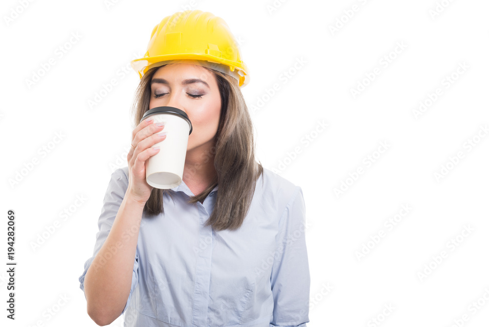 Pretty female constructor drinking takeaway coffee. Pretty female constructor drinking takeaway coffee.