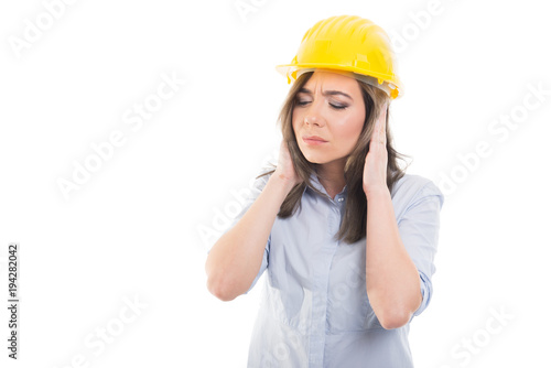 Portrait of female constructor covering her ears.