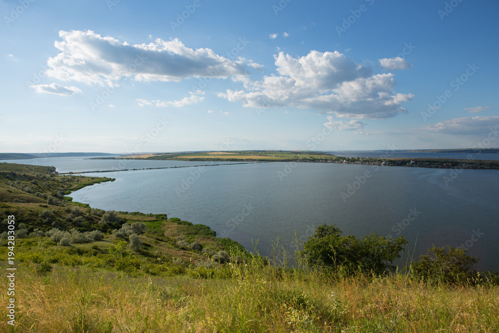 beautiful view of a natural pond, a lake or estuary, a blue sky with a big cloud