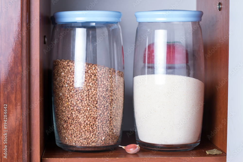 Glass jars with cereals in a kitchen cupboard. stocked kitchen pantry with food Glass jars with cereals in a kitchen cupboard. stocked kitchen pantry with food