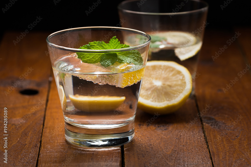 Fototapeta premium Lemonade with fresh lemon on wooden background