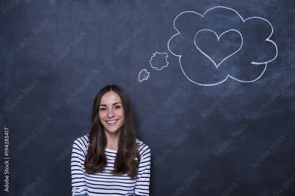Loving young woman with a pattern of heart over her at the blackboard Loving young woman with a pattern of heart over her at the blackboard