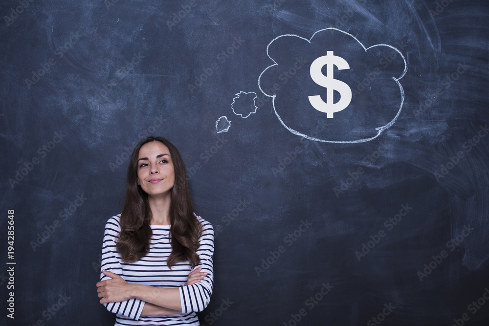 Thoughtful confident businesswoman is standing near blackboard with large dollar sign drawn on it. Concept of money management Thoughtful confident businesswoman is standing near blackboard with large dollar sign drawn on it. Concept of money management