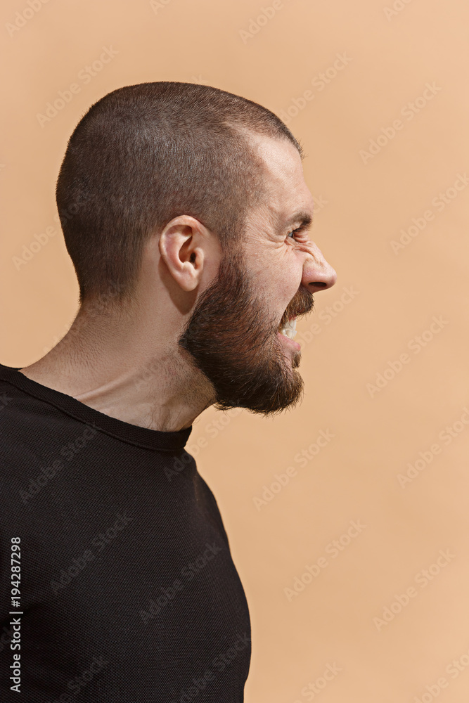 Fototapeta premium The young emotional angry, crazy man on pastel studio background