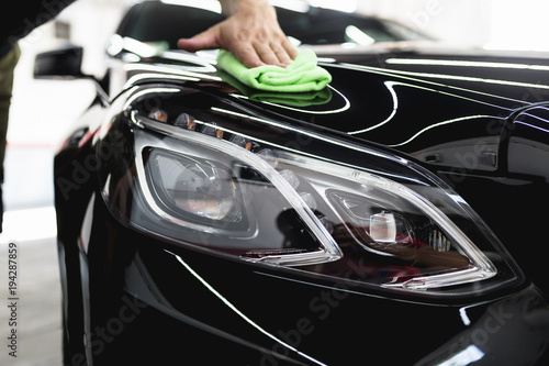 A man cleaning car with microfiber cloth, car detailing (or valeting) concept. Selective focus.  © hedgehog94