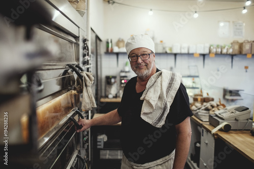 Portrait of baker next to oven photo