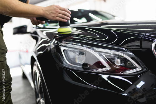 Car detailing - Worker with orbital polisher in auto repair shop. Selective focus. © hedgehog94