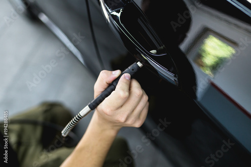 Car detailing - Worker with orbital polisher in auto repair shop. Selective focus. © hedgehog94