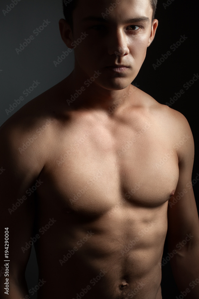 Fototapeta premium Athletic young man in studio on the black background