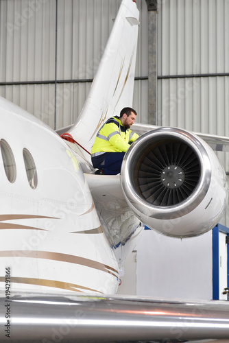 Airport workers check an aircraft for safety in a hangar