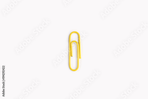 Yellow paper clip on a white background.