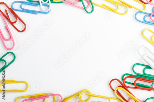 A lot of colorful paper clips on white background.