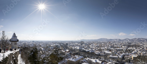 panoramic view of clocktower uhrturm on schlossberg hill in winter, graz, austria