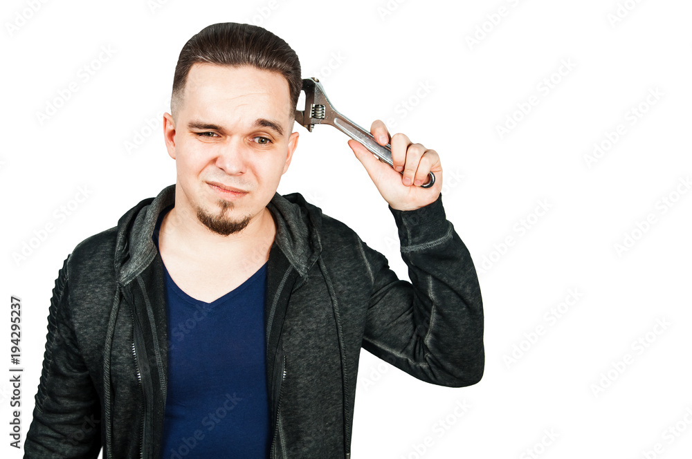 Portrait of thinking bearded young man holding adjustable wrench. isolated on white. Portrait of thinking bearded young man holding adjustable wrench. isolated on white.