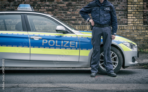 Polizist neben Polizeiauto (Deutschland) photo