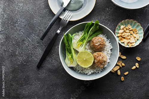 Meatballs, rice, bok choy bowl on a gray background with a ceramic dish. Flat lay. Top view. photo
