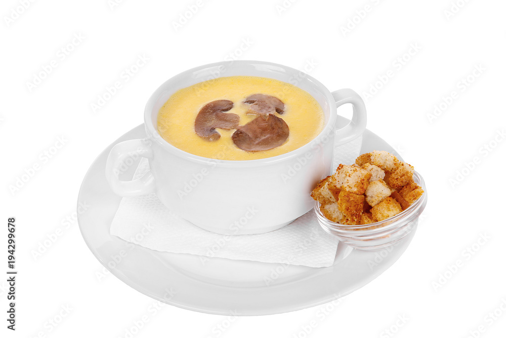 Soup puree, cream soup yellow with mushrooms, championons and crackers, dry bread. On a napkin in a white plate isolated white. Serving dishes in a cafe, restaurant, for a menu. Side view Soup puree, cream soup yellow with mushrooms, championons and crackers, dry bread. On a napkin in a white plate isolated white. Serving dishes in a cafe, restaurant, for a menu. Side view