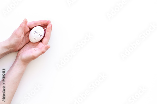 Fototapeta Naklejka Na Ścianę i Meble -  Emotions. Happy, in love. Face drawn on egg. White background top view copy space