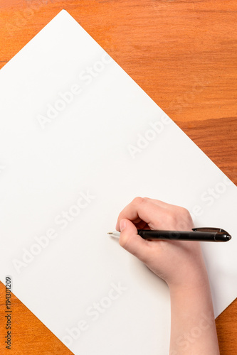 Hand of a little boy with a black pen on a white background photo