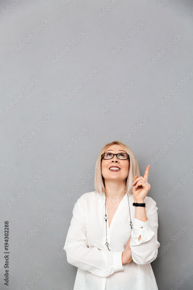 Vertical image of Smiling middle-aged woman in shirt and eyeglasses Vertical image of Smiling middle-aged woman in shirt and eyeglasses