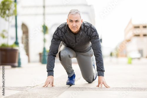 Fit mature man ready for his run in the city