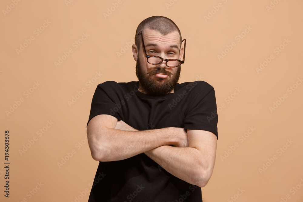 Suspiciont. Doubtful pensive man with thoughtful expression making choice against pastel background Suspiciont. Doubtful pensive man with thoughtful expression making choice against pastel background