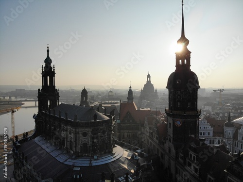 4K Aerial drone shot of sunrise in Dresden inner city with Frauenkirche, Hofkirche, Zitronenpresse with beautiful sun reflections and Elbe river photo