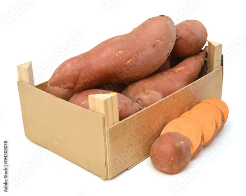 Bunch of sweet potatoes in a wooden crate on a white background photo