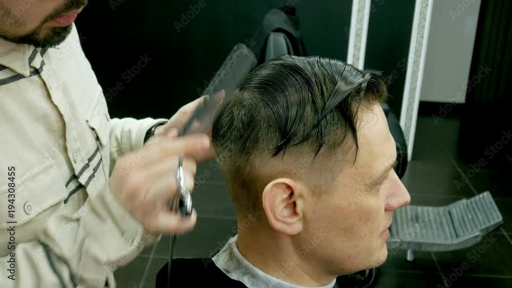 Barber cuts the hair of the client with scissors Barber cuts the hair of the client with scissors