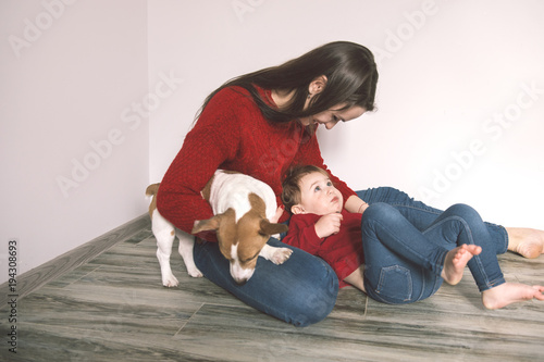 Mom with child and pet dog have a fun at home