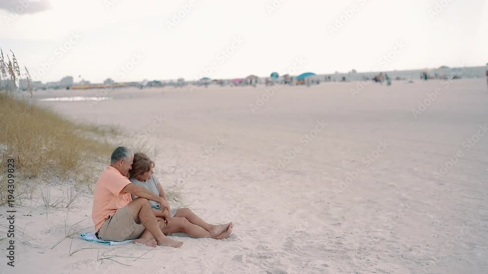 Couple Laughing, Sitting on Clearwater Beach Couple Laughing, Sitting on Clearwater Beach