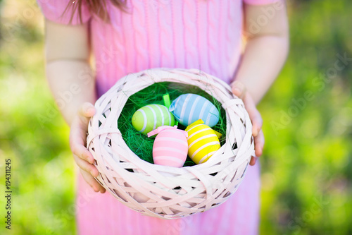 Kids on Easter egg hunt with eggs basket.