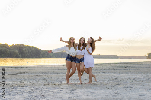 Three beautiful girls on the sandy beach © pucko_ns