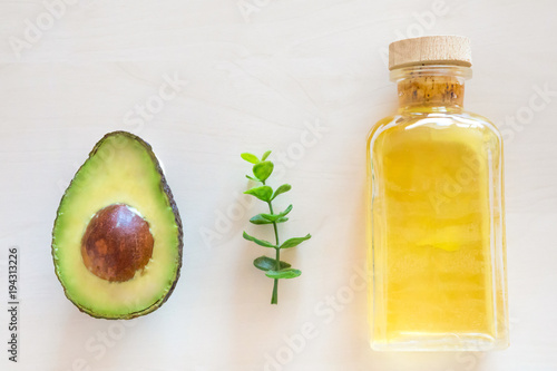 Fresh Avocado and oil in bottle on wooden background