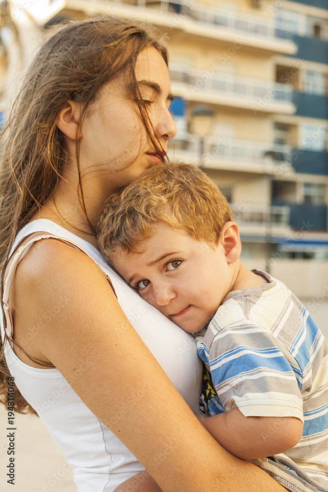 Fototapeta premium Close up sleepy little boy lean on sisters arms.