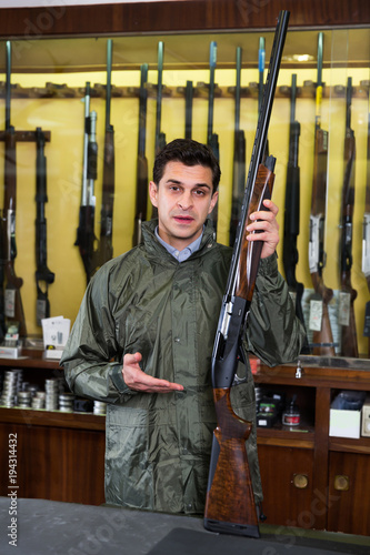 Portrait of confident man showing rifle