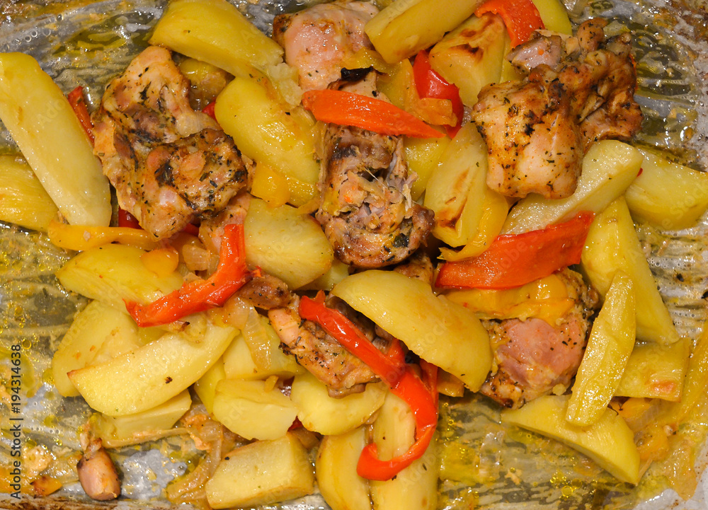 Potatoes with meat and vegetables baked in the oven on baking paper. Close-up Potatoes with meat and vegetables baked in the oven on baking paper. Close-up