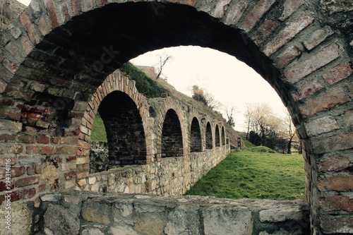 Fotografija Ancient red brick archways with green grass park