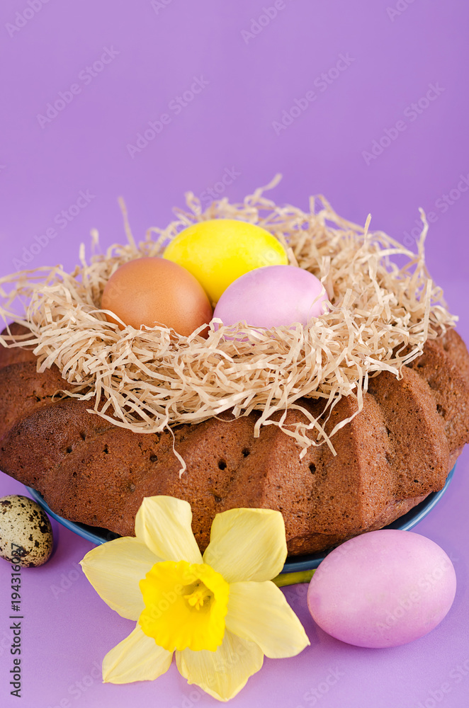 Obraz premium Easter still life, Easter cake, chicken and quail eggs, on a violet background.